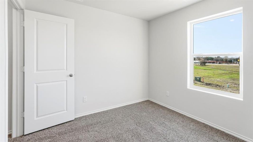 Carpeted empty room with baseboards