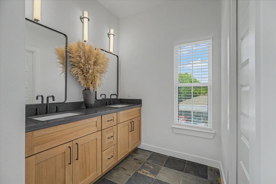 This bathroom features a double vanity with soft-close cabinets and drawers for ample storage.