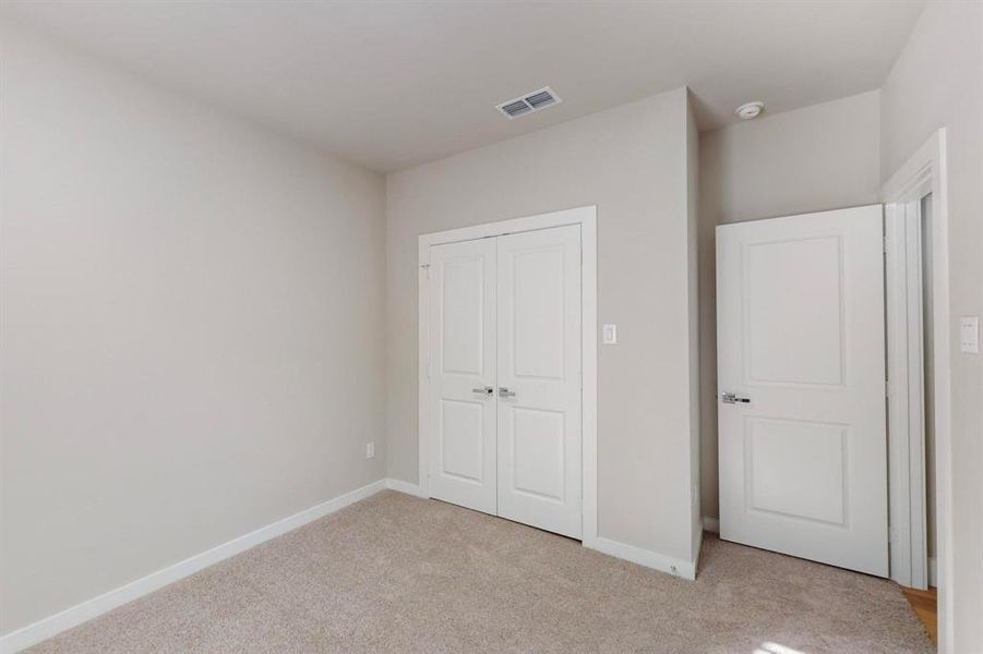 Unfurnished bedroom featuring a closet and light colored carpet