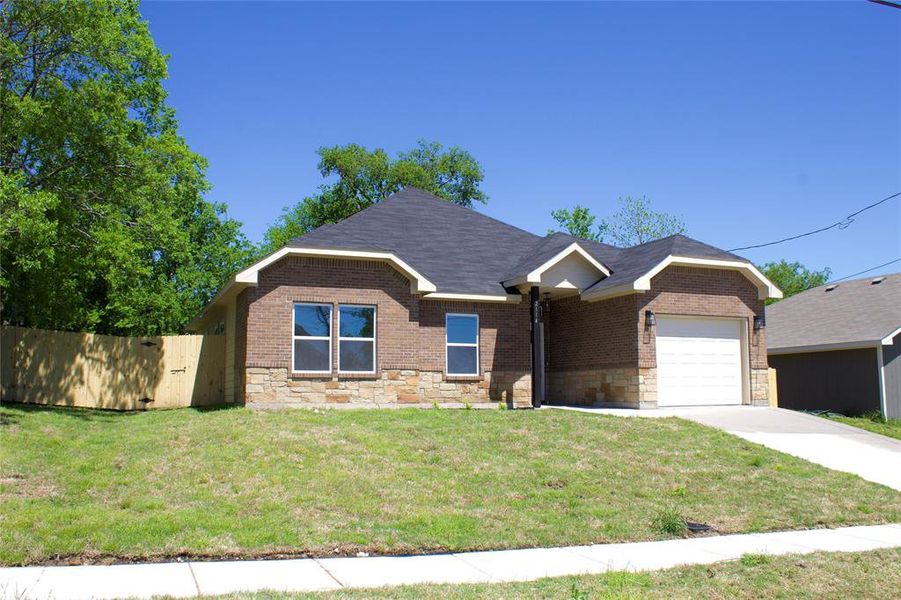 View of front facade featuring a front lawn and a garage