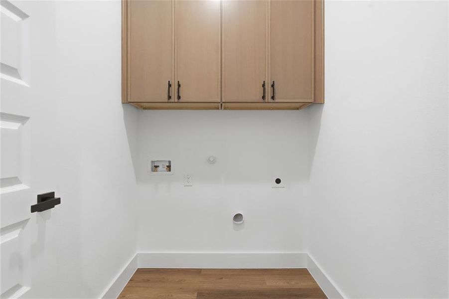Laundry room featuring gas dryer hookup, light wood finished floors, washer hookup, and cabinet space