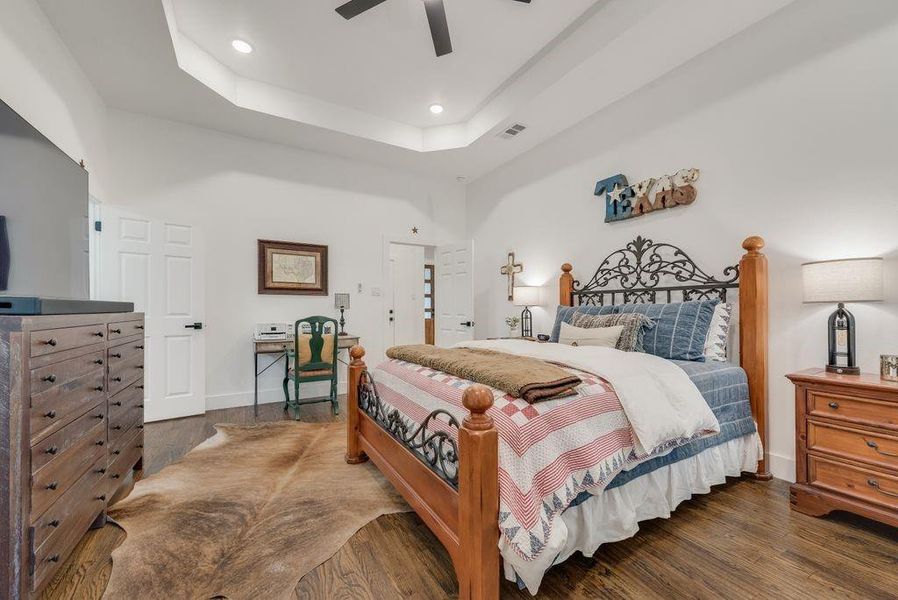 Bedroom featuring wood finished floors, a raised ceiling, ceiling fan, and recessed lighting
