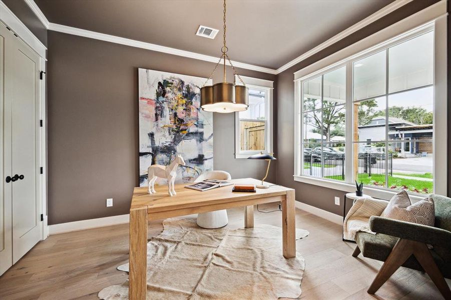 The study/5th bedroom is located at the front of the house overlooking the front porch and yard. The walls and ceiling are painted a warm truffle color and is anchored by a stylish light fixture.