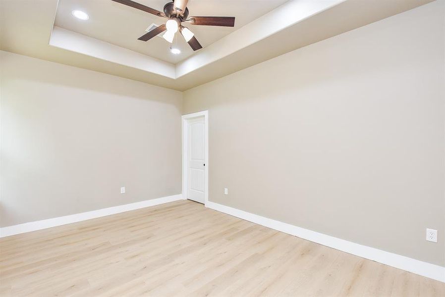 Primary Bedroom with Tray Ceiling, LED Lighting, and Ceiling Fan.