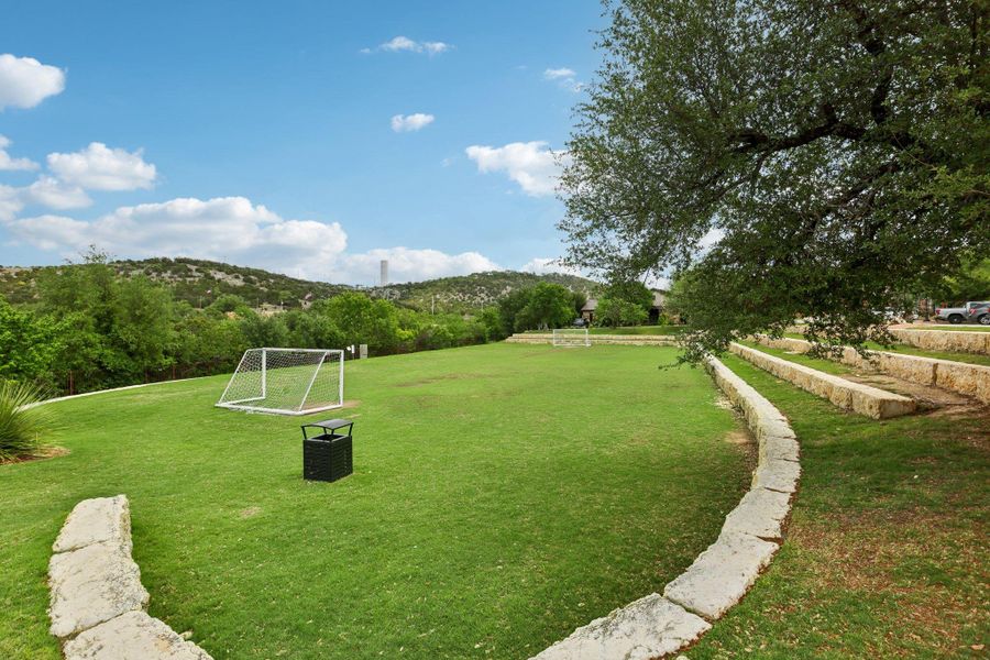 Expansive grassy area featuring two soccer goals and tiered stone retaining walls