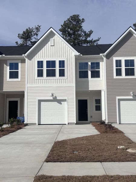 Front exterior of a new home in Lindera Preserve at Cane Bay Plantation: Townhomes, Summerville, SC, highlighting curb appeal (Image 2). Front exterior of a new home in Lindera Preserve at Cane Bay Plantation: Townhomes, Summerville, SC, highlighting curb appeal (Image 2).