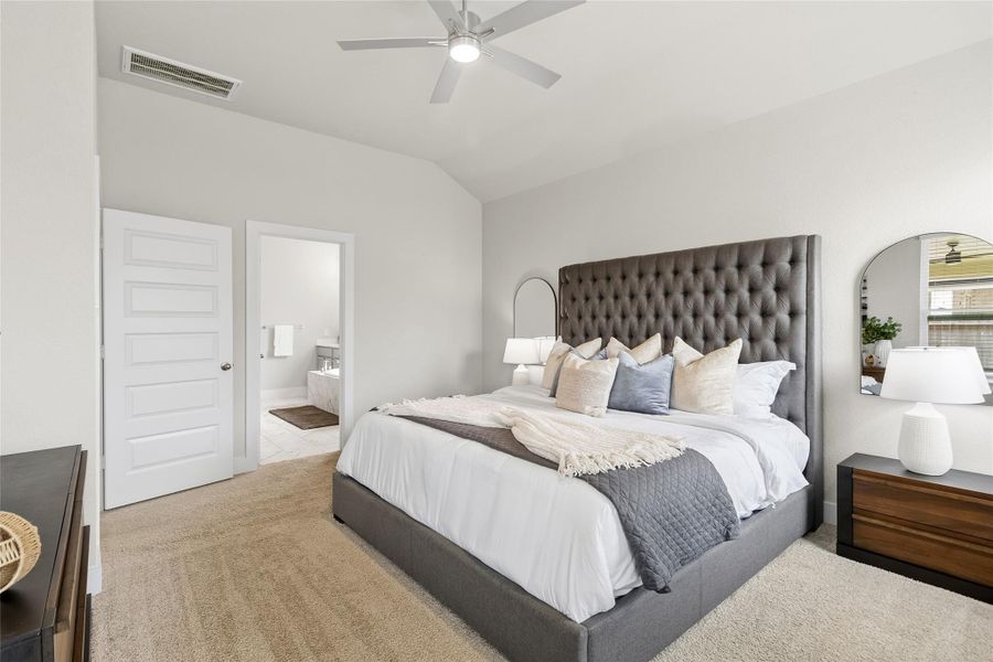 Your spacious primary suite offers a relaxing escape with vaulted ceilings, plush carpeting, and ample room for a king-size bedroom set.