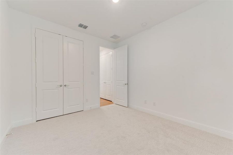 Unfurnished bedroom with a closet and light carpet