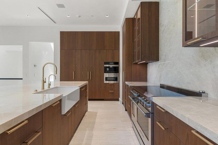 Kitchen featuring range with two ovens, light stone countertops, and modern cabinets
