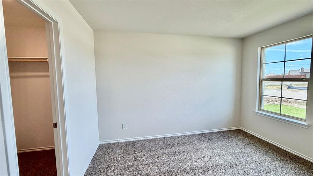 Carpeted room with a single window and an open closet