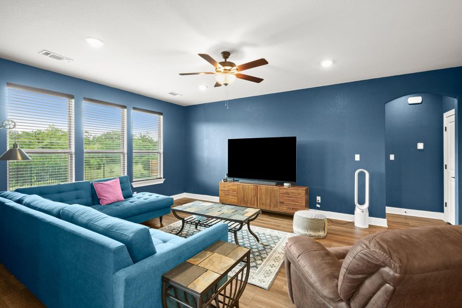 Living area featuring wood finished floors, ceiling fan, arched walkways, and recessed lighting Living area featuring wood finished floors, ceiling fan, arched walkways, and recessed lighting