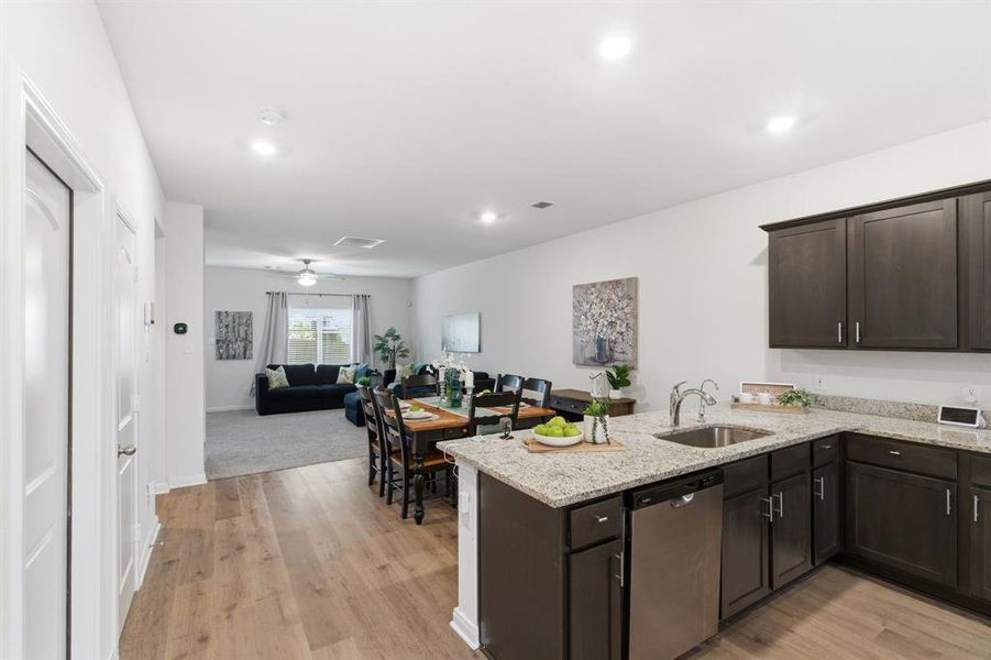The kitchen features dark wood cabinetry, granite countertops, and stainless steel appliances