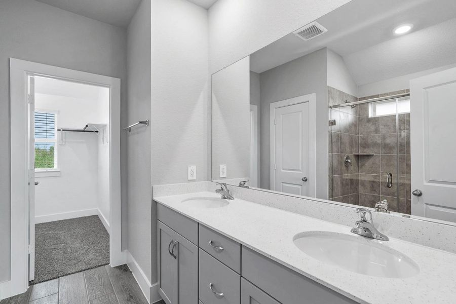 A bright and functional primary bath offering dual sinks for busy mornings, a large seamless mirror, and a modern glass-enclosed shower, creating a serene and efficient space. A bright and functional primary bath offering dual sinks for busy mornings, a large seamless mirror, and a modern glass-enclosed shower, creating a serene and efficient space.