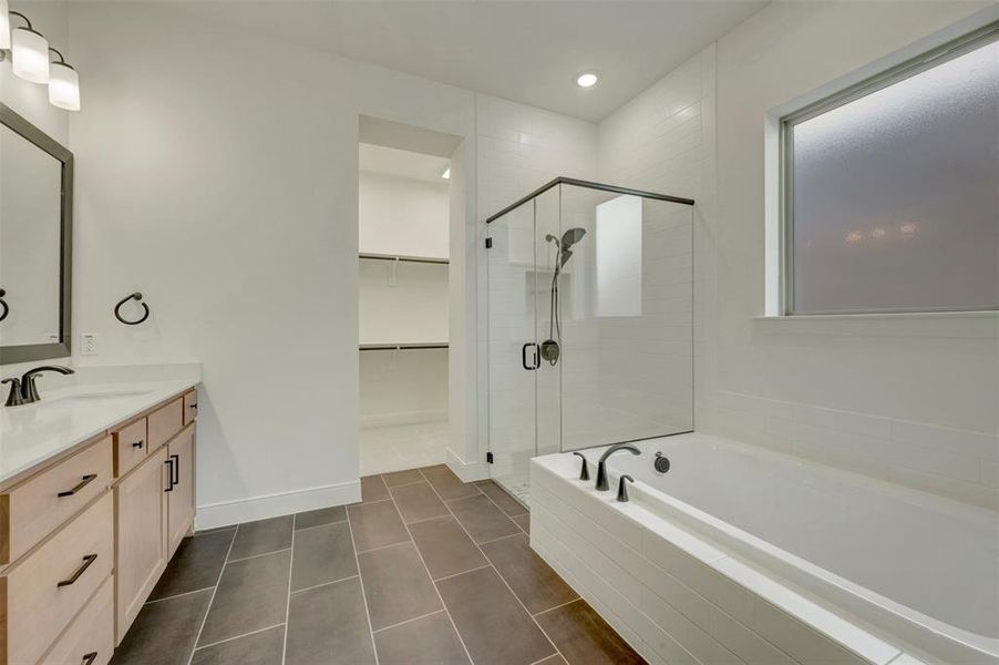 Modern bathroom featuring a soaking tub, glass-enclosed shower, and a light wood-finish vanity with quartz countertop Modern bathroom featuring a soaking tub, glass-enclosed shower, and a light wood-finish vanity with quartz countertop