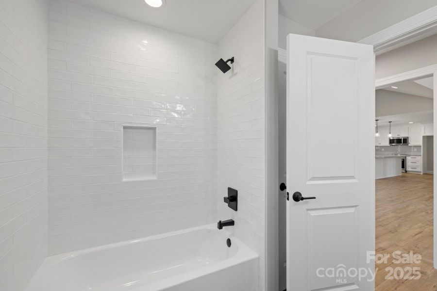 Beautiful tub/shower combo with full-height subway tile, built-in niche, and matte black fixtures—shared conveniently between the secondary bedrooms. Beautiful tub/shower combo with full-height subway tile, built-in niche, and matte black fixtures—shared conveniently between the secondary bedrooms.