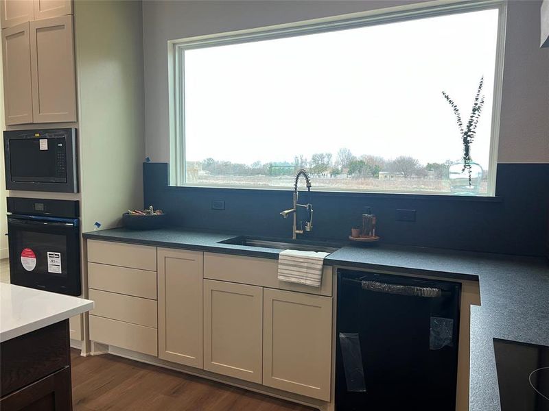 Kitchen with sink, white cabinets, dark hardwood / wood-style flooring, and black appliances