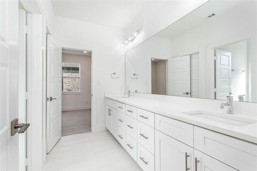 Full bathroom featuring double vanity and light tile patterned floors