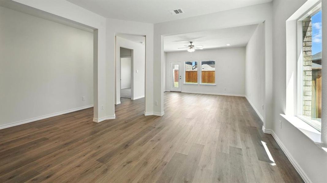 Unfurnished living room featuring dark wood-style flooring and ceiling fan