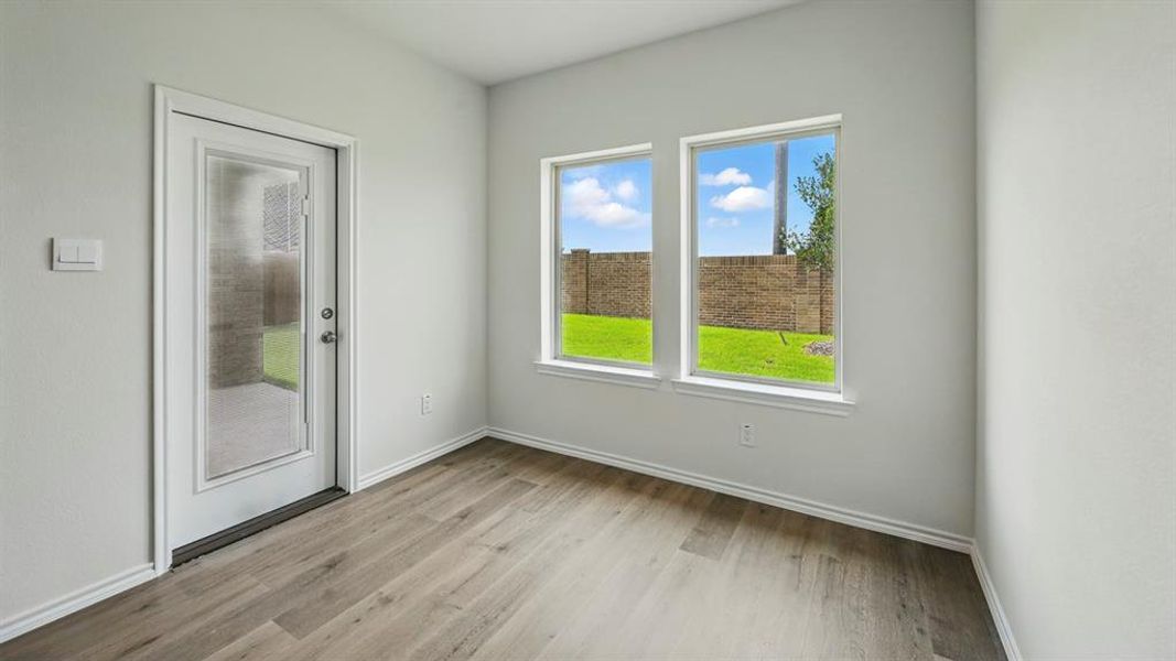 Spare room featuring light wood finished floors and baseboards