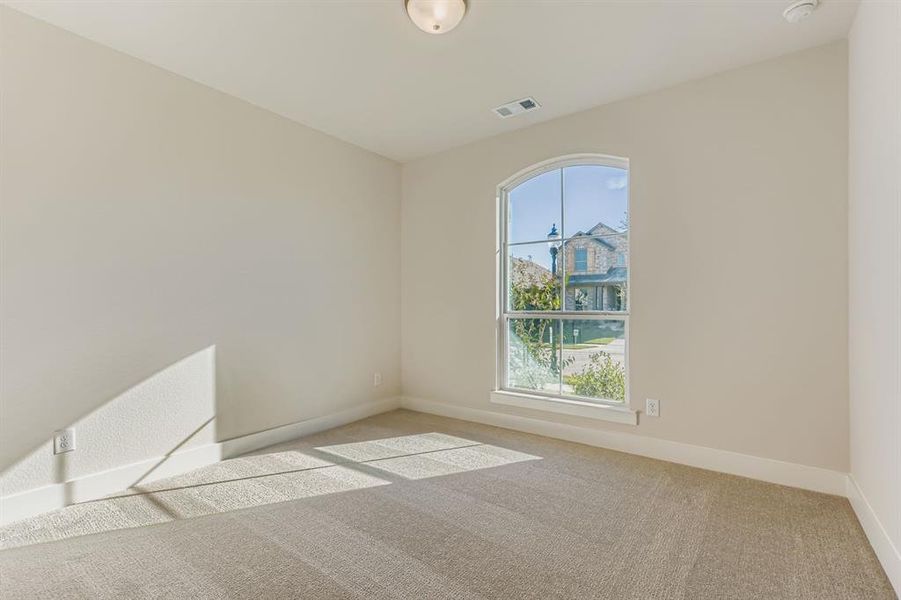 Empty room with light colored carpet and baseboards