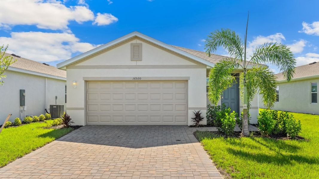 Front exterior of a new home in Coral Bay - Express & Tradition, North Fort Myers, FL, highlighting curb appeal (Image 1).