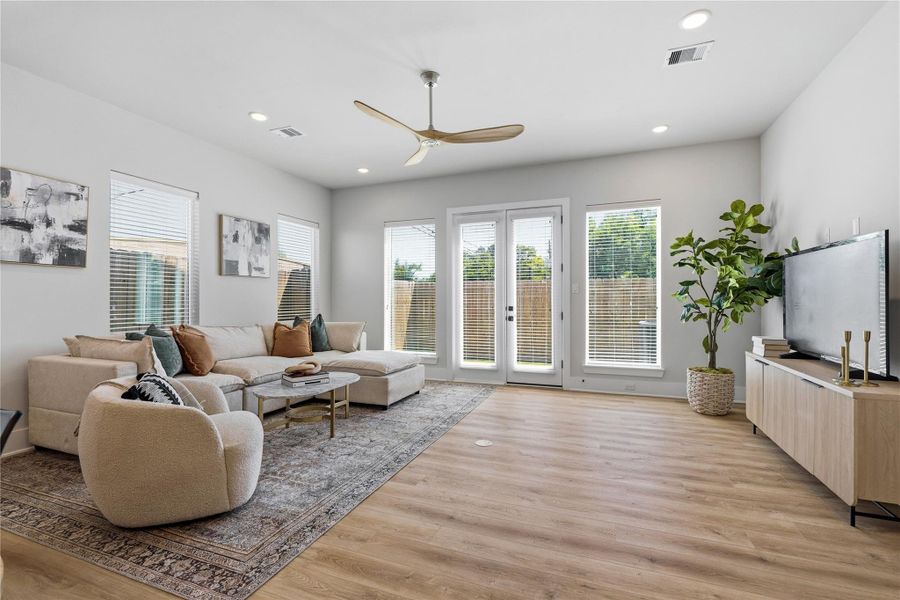 Surrounded by perimeter windows, the living space is filled with natural light, enhancing the warmth of the flooring and overall openness. Surrounded by perimeter windows, the living space is filled with natural light, enhancing the warmth of the flooring and overall openness.