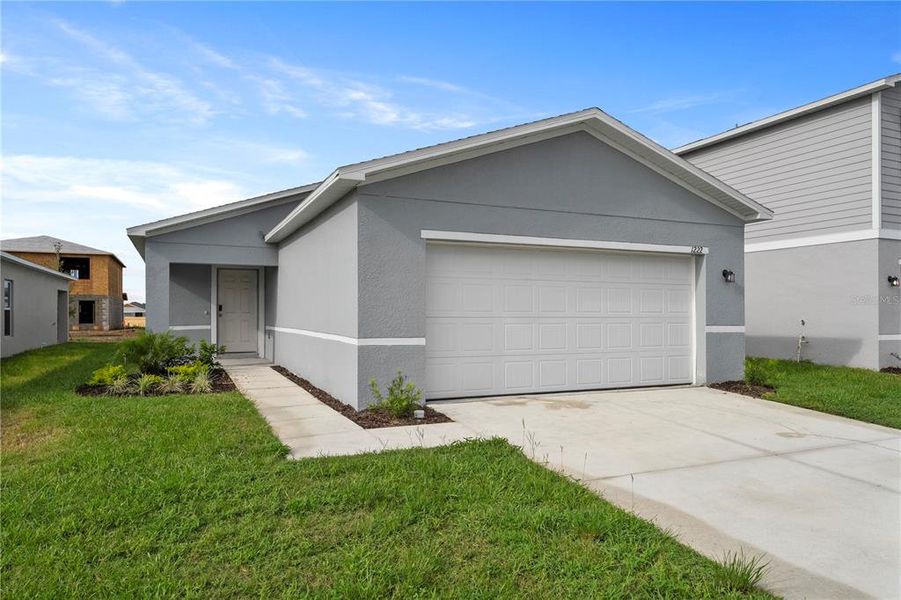Front exterior of a new home in Eagle Hammock, Eagle Lake, FL, highlighting curb appeal (Image 26). Front exterior of a new home in Eagle Hammock, Eagle Lake, FL, highlighting curb appeal (Image 26).