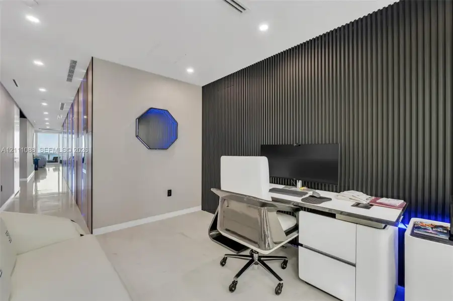 Interior space featuring large-format tile flooring, a floor-to-ceiling ribbed accent wall, and recessed LED ceiling lighting Interior space featuring large-format tile flooring, a floor-to-ceiling ribbed accent wall, and recessed LED ceiling lighting