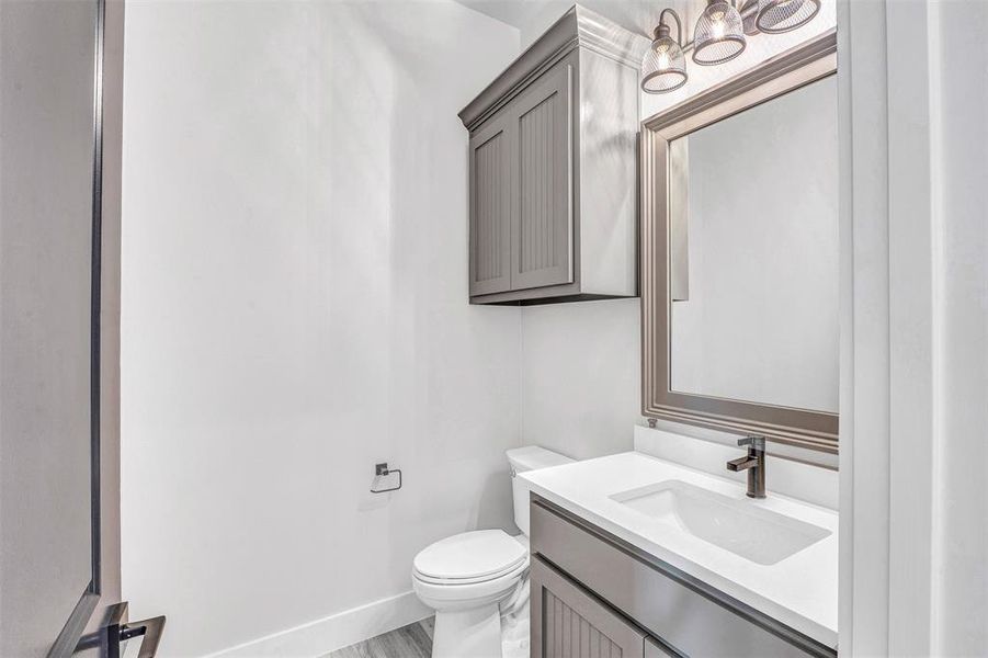 Bathroom with vanity, toilet, and wood-type flooring