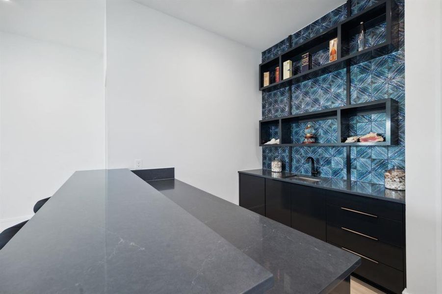 Upstairs Bar featuring sink and dark stone countertops