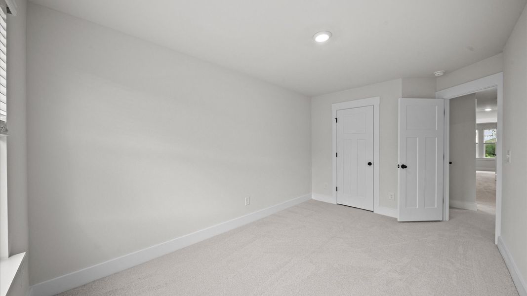 Carpeted bedroom with walk-in closet in two story townhome at Ransdell Pointe by DRB Homes in Spartanburg, SC Carpeted bedroom with walk-in closet in two story townhome at Ransdell Pointe by DRB Homes in Spartanburg, SC