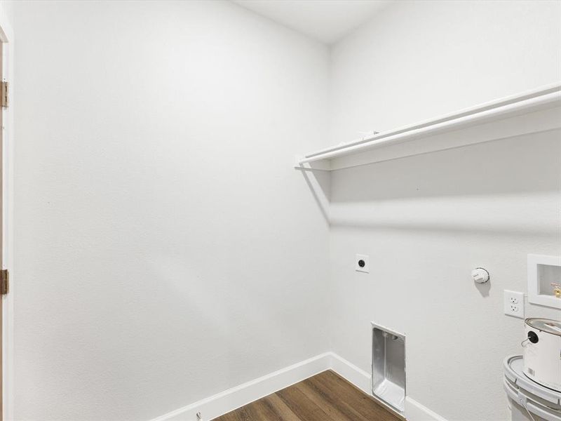 Washroom featuring dark wood-style floors, hookup for an electric dryer, hookup for a washing machine, and hookup for a gas dryer
