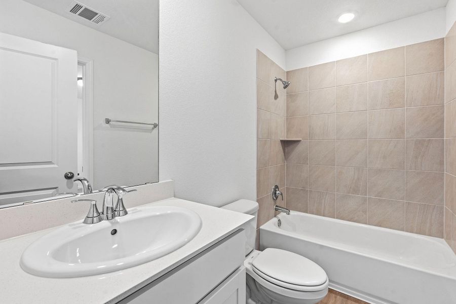 Bathroom featuring a white vanity with an oval sink, chrome faucet, and integrated mirror Bathroom featuring a white vanity with an oval sink, chrome faucet, and integrated mirror