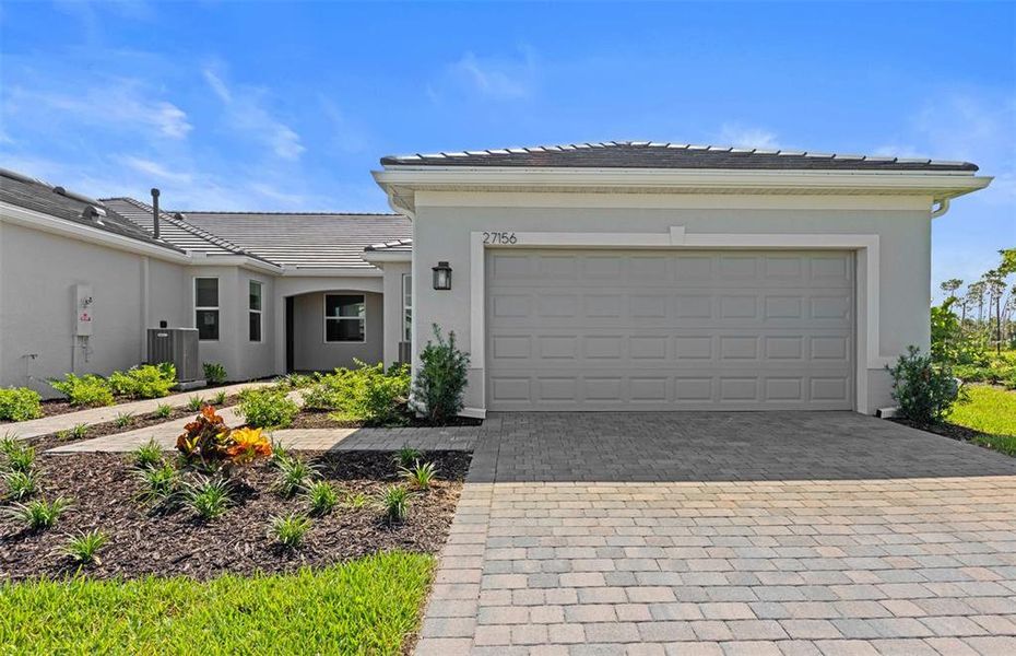 Front exterior of a new home in BeachWalk by Manasota Key, Englewood, FL, highlighting curb appeal (Image 1). Front exterior of a new home in BeachWalk by Manasota Key, Englewood, FL, highlighting curb appeal (Image 1).