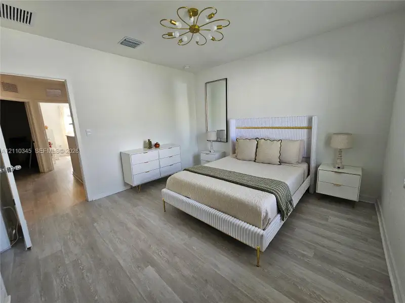 Interior space featuring wood-finish flooring, a multi-arm brass-tone chandelier, and a neutral color palette