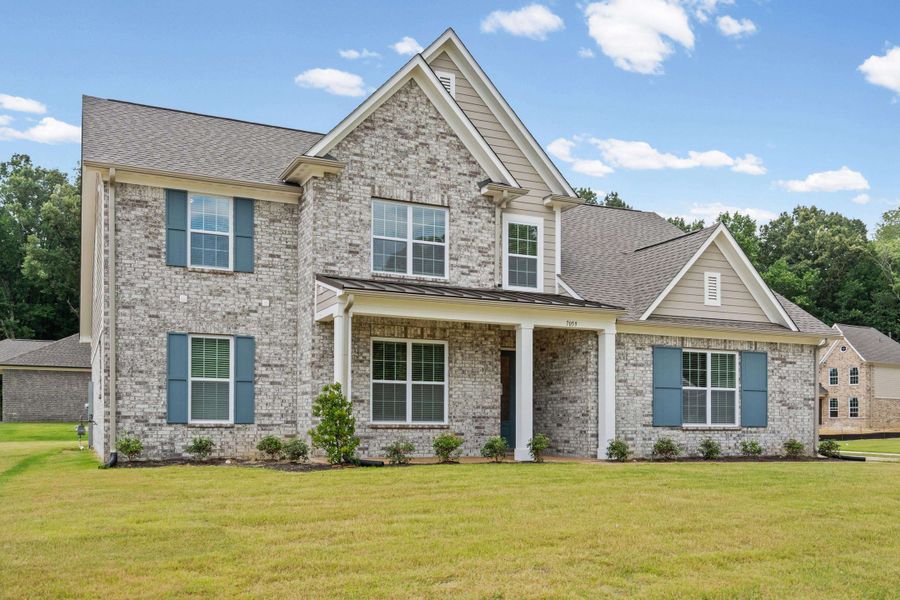 Two-story residence featuring a light-toned brick facade with coordinating gray siding accents Two-story residence featuring a light-toned brick facade with coordinating gray siding accents