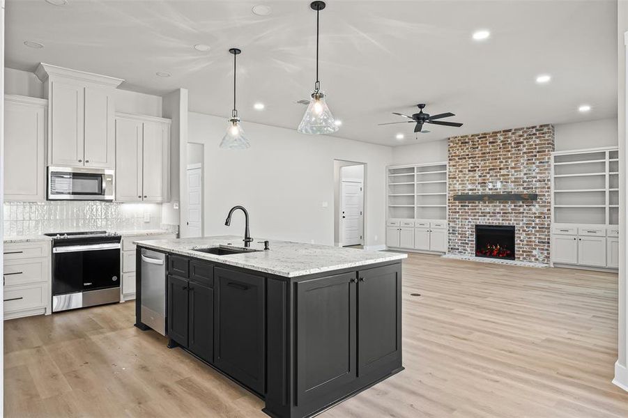 Kitchen featuring white cabinets, light stone countertops, recessed lighting, hanging light fixtures, and stainless steel appliances Kitchen featuring white cabinets, light stone countertops, recessed lighting, hanging light fixtures, and stainless steel appliances