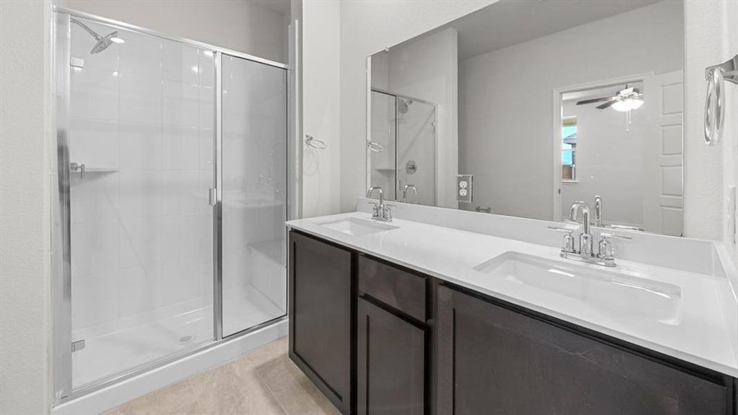 Bathroom featuring a stall shower and a sink