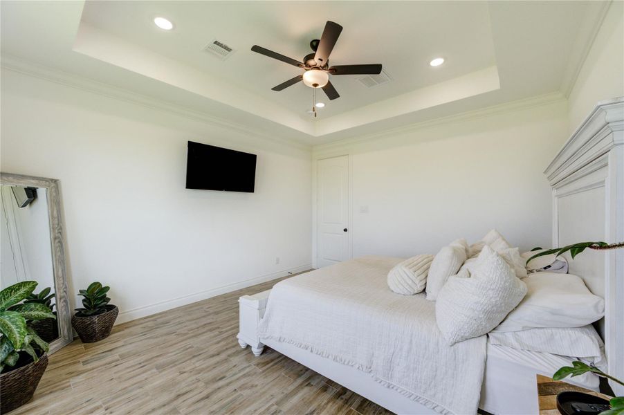 Spacious primary bedroom offering a calm, inviting atmosphere with room for a seating or media area