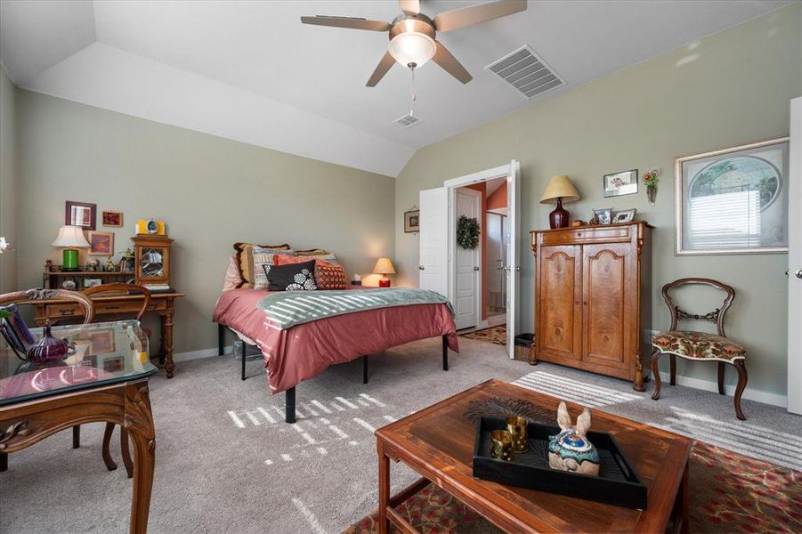 Carpeted bedroom with vaulted ceiling and a ceiling fan Carpeted bedroom with vaulted ceiling and a ceiling fan