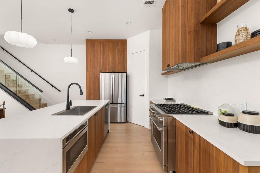Modern kitchen with sleek wooden cabinetry and stainless steel appliances.