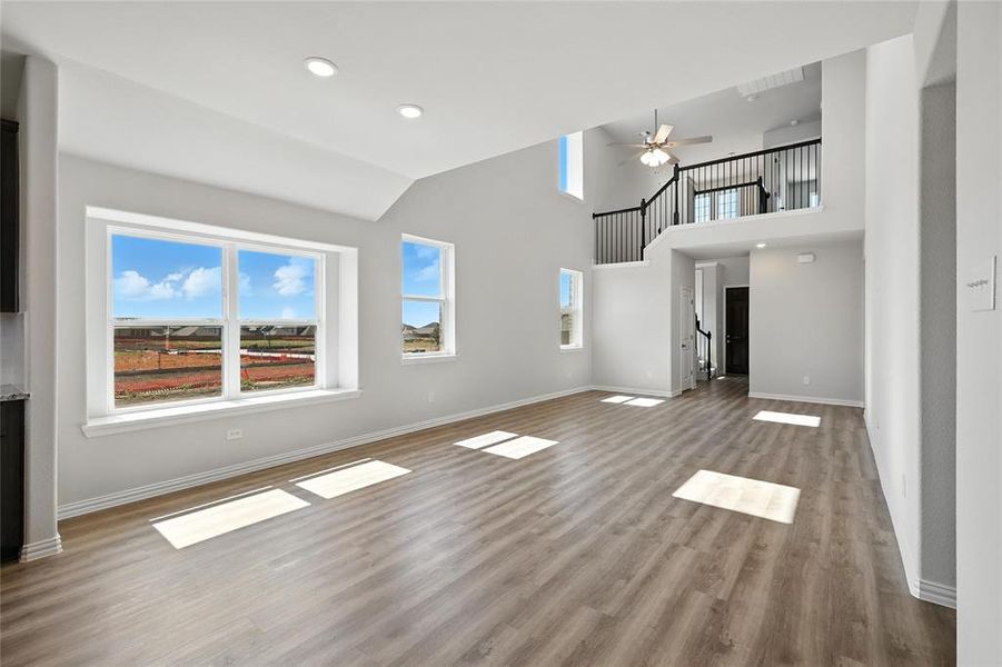 Unfurnished living room with wood finished floors, a ceiling fan, recessed lighting, and vaulted ceiling Unfurnished living room with wood finished floors, a ceiling fan, recessed lighting, and vaulted ceiling