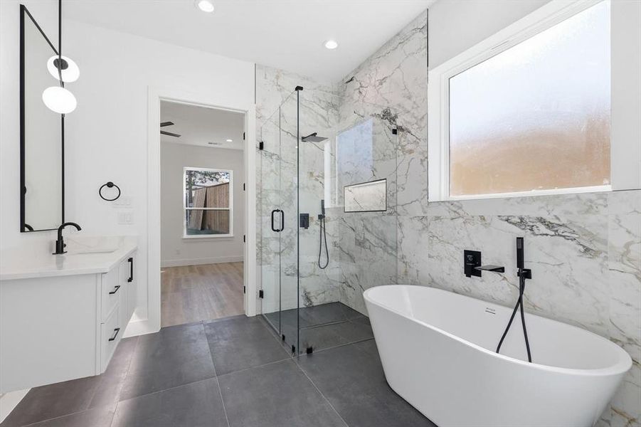 Bathroom featuring a freestanding tub, vanity, a marble finish shower, and recessed lighting Bathroom featuring a freestanding tub, vanity, a marble finish shower, and recessed lighting