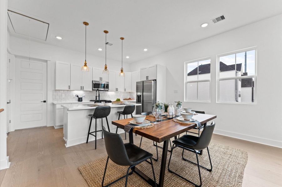 This inviting dining space sits perfectly between the modern kitchen and comfortable living room, creating a natural flow ideal for entertaining and everyday living. The open layout allows for effortless interaction across zones, while stylish lighting and tasteful furnishings define the area without disrupting the spacious feel. Whether hosting dinner parties or enjoying casual meals, this central hub brings warmth and connectivity to the heart of the home.