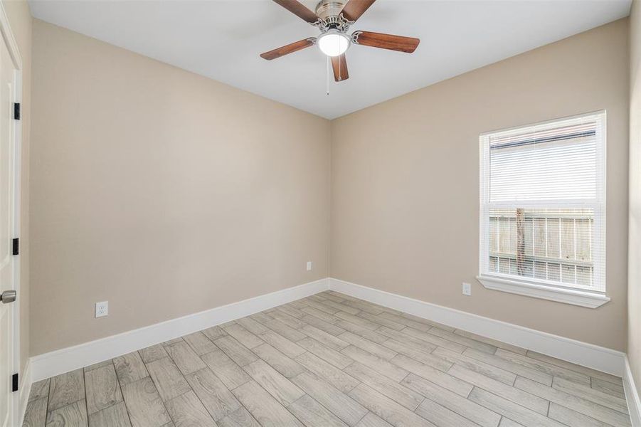 Empty room with light hardwood / wood-style flooring and ceiling fan