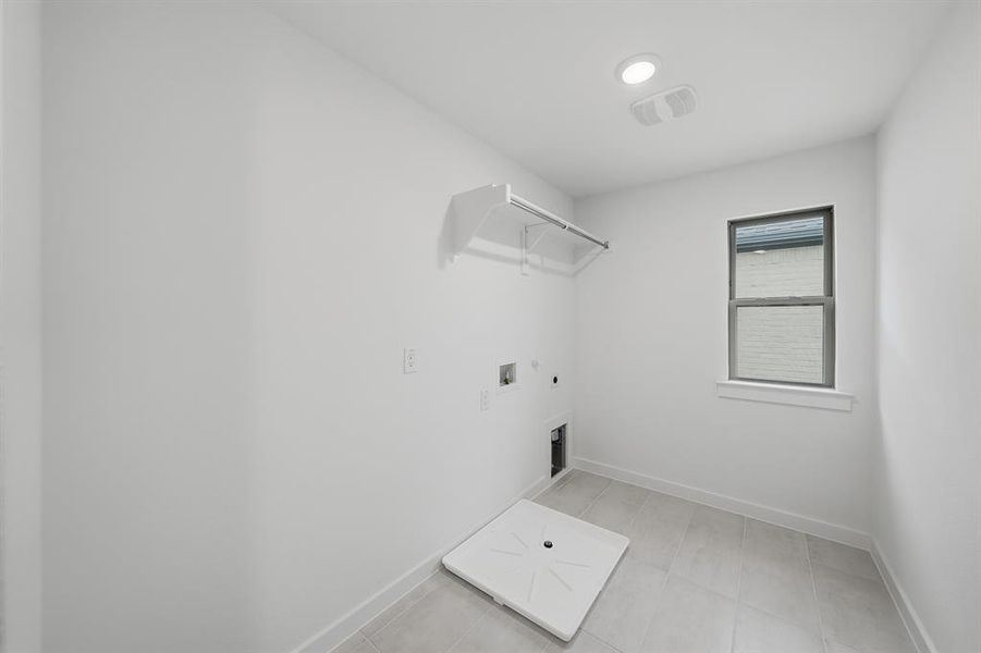 Laundry area with hookup for a washing machine, electric dryer hookup, and hookup for a gas dryer