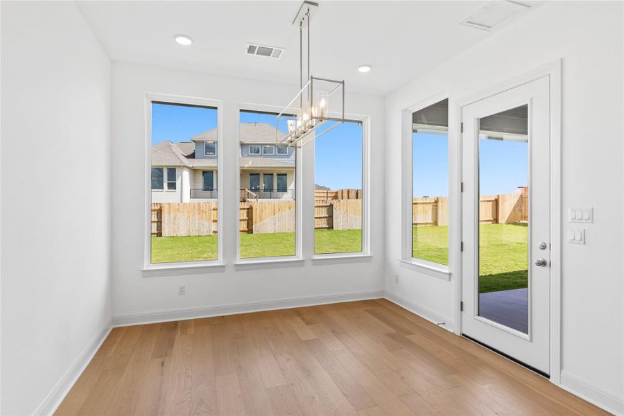 Unfurnished dining area with a chandelier and light wood-style flooring