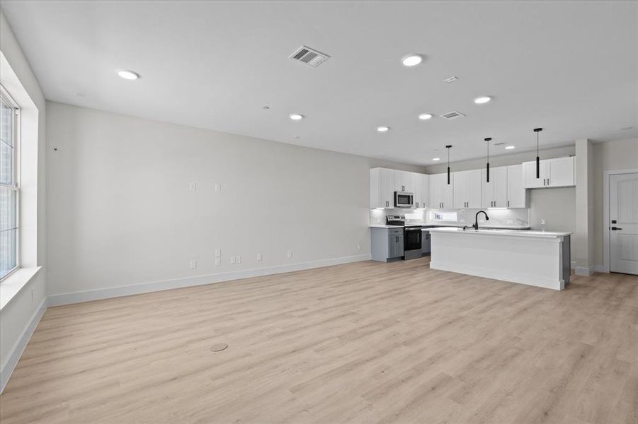 Unfurnished living room with light wood finished floors and recessed lighting