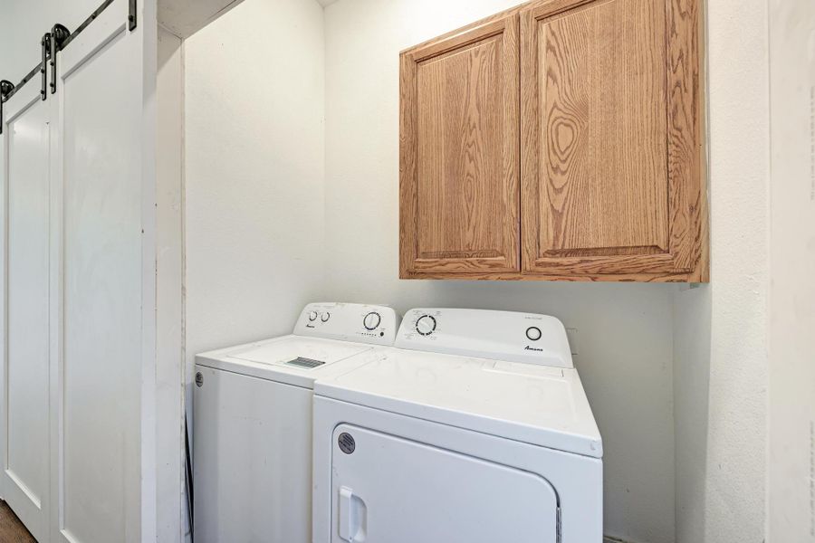 Functional utility space includes built-in cabinetry alongside sliding barn doors.