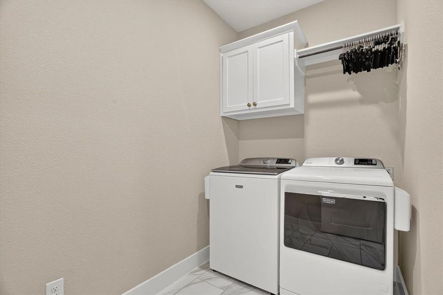 Dedicated laundry area featuring white wall cabinetry, a hanging rod, and a neutral wall finish Dedicated laundry area featuring white wall cabinetry, a hanging rod, and a neutral wall finish